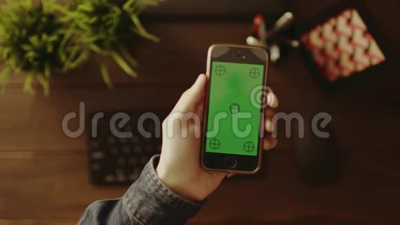 使用绿色屏幕智能手机的人的俯视图视频的预览图
