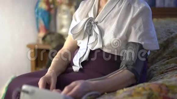 老妇人把血压测量工具放在手边视频的预览图