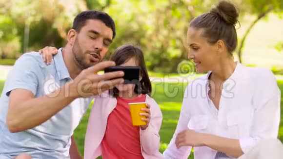 一家人在公园野餐和自拍视频的预览图