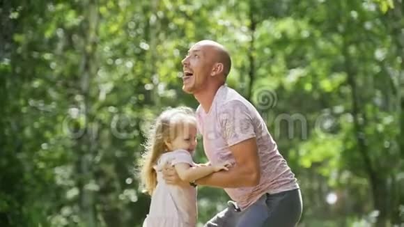 快乐的家庭父亲和他快乐的女儿在夏季公园慢动作视频的预览图