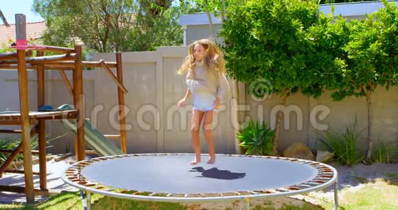 在花园里蹦床上跳的女孩视频的预览图