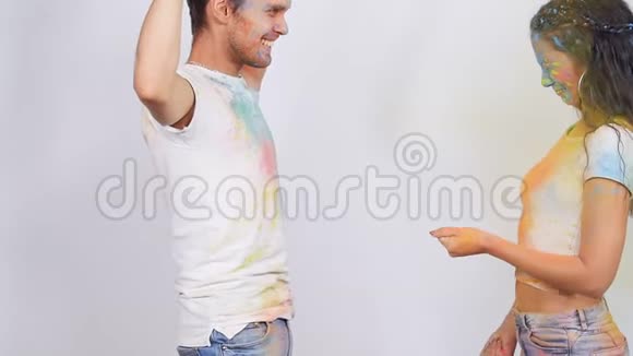 年轻的幸福夫妇玩着五颜六色的冬青粉视频的预览图