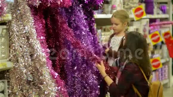 人们在圣诞市场购买圣诞玩具和内衣母亲和孩子在购物中心选择节日装饰视频的预览图