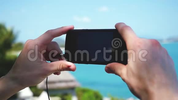 男子旅行者在海滩上用他的智能手机拍照假期概念苏梅岛1920x1080视频的预览图