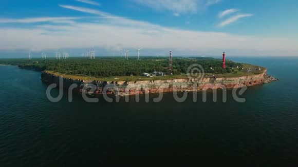 从海上和陆地上的旧灯塔和风力涡轮机上用岩石俯瞰海岸线视频的预览图