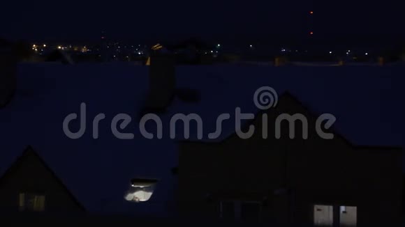 夜间4K平底锅拍摄的白雪倾斜的住宅屋顶视频的预览图