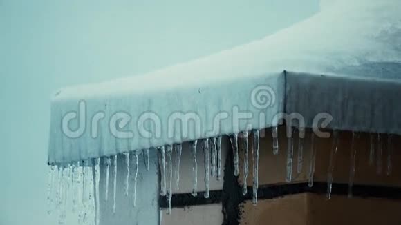 冬季住宅的冰柱和积雪倾斜的屋顶4K高射焦弹视频的预览图