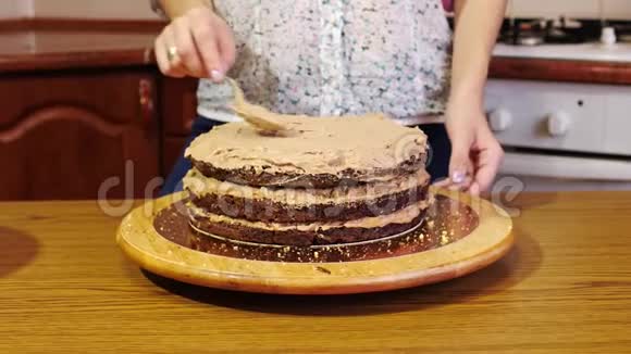 用勺子把奶油用手贴在巧克力海绵蛋糕上视频的预览图