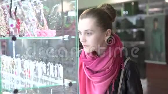 在购物中心检查珠宝橱窗的漂亮女孩4K视频的预览图