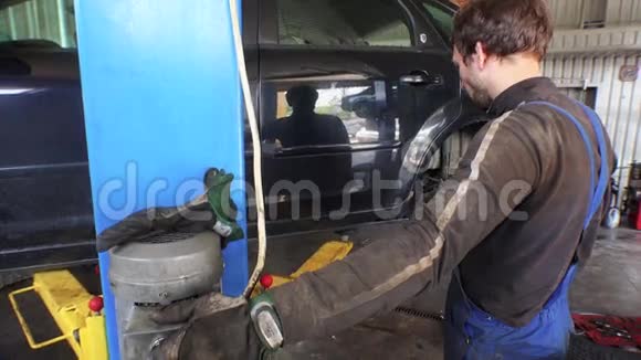 机械师使用液压电梯在车库中提升汽车视频的预览图