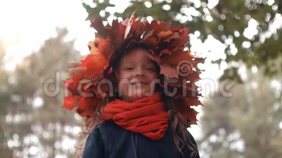 秋枫叶花圈冠上幸福微笑可爱小女孩的特写视频的预览图