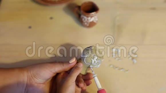 小男孩在儿童陶艺工作坊上画陶罐的特写镜头视频的预览图