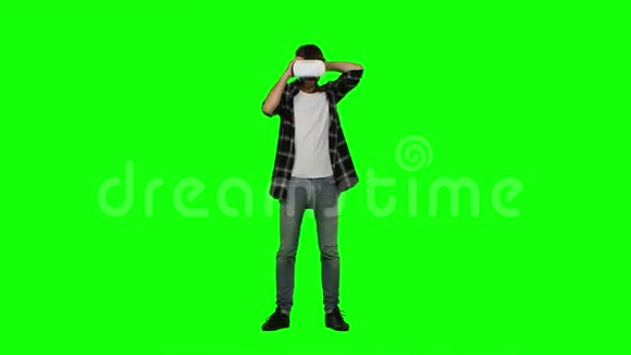 戴虚拟现实护目镜的人摄影棚拍摄绿色屏幕视频的预览图