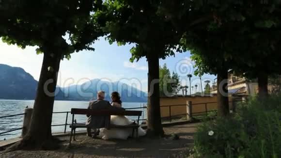 新婚夫妇在意大利科莫湖的长凳上接吻视频的预览图