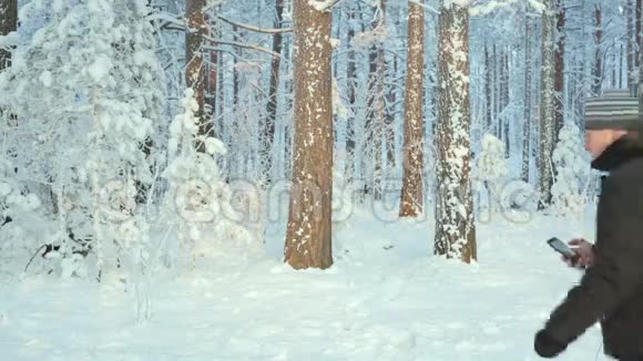 一个迷路的人在冬天的森林里打电话视频的预览图