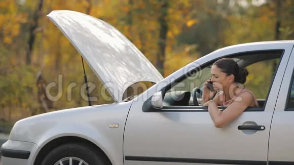 一辆破车里的女人打电话视频的预览图