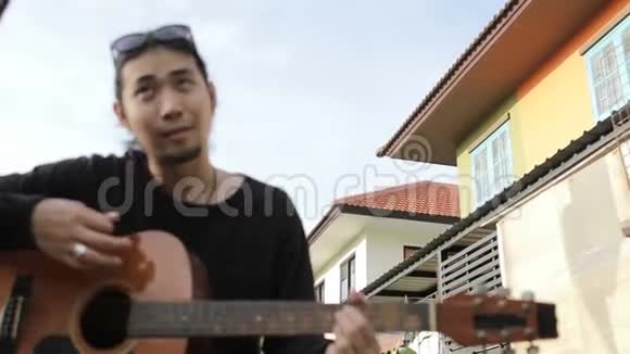亚洲年轻男女在花园里轻松弹吉他视频的预览图