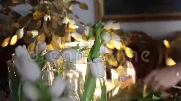 在工作的花商透明玻璃花瓶中的白色郁金香桌上的金色花朵视频的预览图