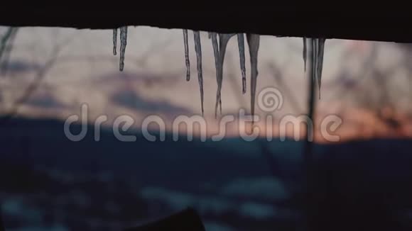 山中日落模糊背景下融化的冰柱的组成视频的预览图