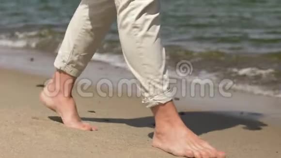 光脚在夏日海滩上行走的女人的脚视频的预览图