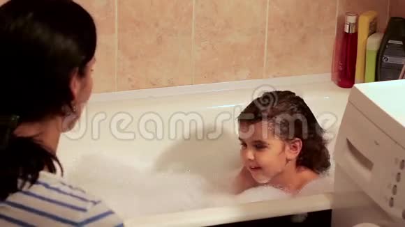 妈妈用泡沫把漂亮的女儿洗澡为洗澡玩玩具玩得开心视频的预览图