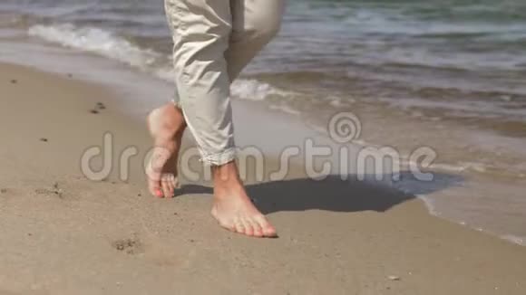光脚在夏日海滩上行走的女人的脚视频的预览图