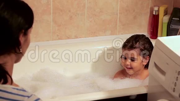 妈妈用泡沫把漂亮的女儿洗澡为洗澡玩玩具玩得开心视频的预览图