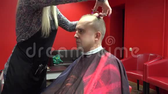 女理发师在自己的理发店剪男客户4K视频的预览图