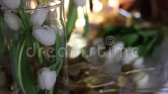 在工作的花商透明玻璃花瓶中的白色郁金香桌上的金色花朵视频的预览图
