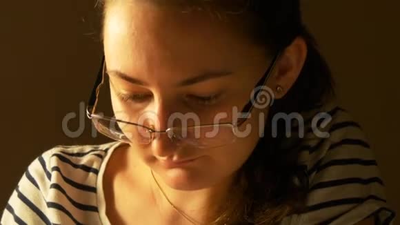 戴眼镜的漂亮年轻女人在家工作视频的预览图