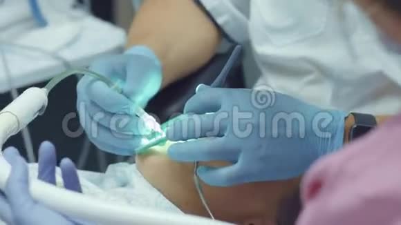牙医在助手的帮助下治疗病人生病的牙齿视频的预览图