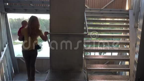 妈妈抱着孩子爬下观景台的楼梯4公里视频的预览图
