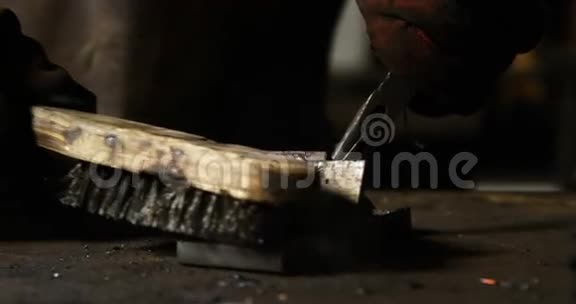 焊工用钢丝刷在一块金属上的手视频的预览图