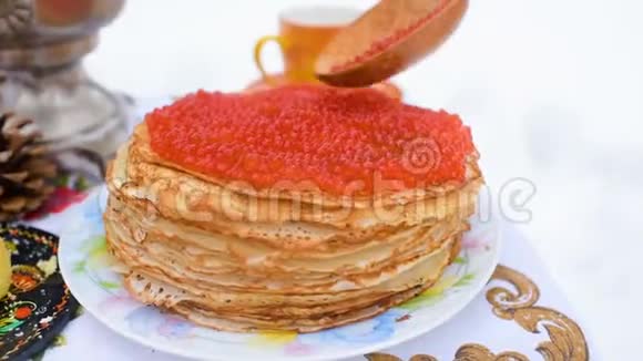 在节日餐桌的背景上带有红色鱼子酱的煎饼在俄罗斯庆祝狂欢节视频的预览图