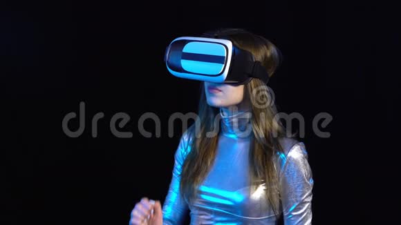 戴着虚拟现实谷歌的银色服装的网络年轻女子视频的预览图