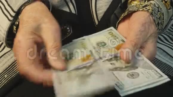 老妇人手里数着百美元钞票视频的预览图