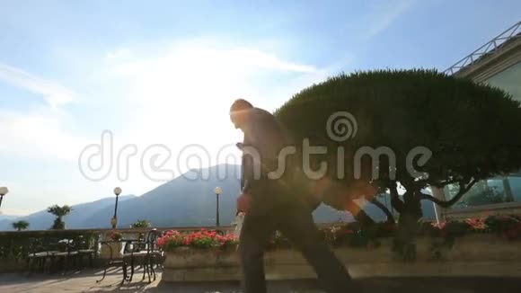 快乐的新郎跑到他的新娘在夏天的露台上拉尔科莫意大利蜜月视频的预览图