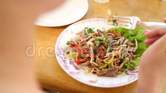 有人用叉子和刀子吃肉沙拉特写镜头慢动作视频的预览图