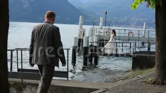 幸福的新婚夫妇在意大利科莫的泊位上散步视频的预览图