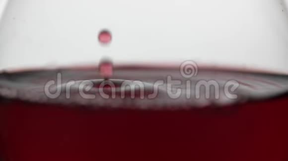 把一滴落在杯子里的红酒关上白色背景玫瑰酒视频的预览图