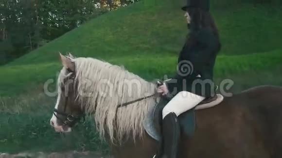 在绿色自然的背景下近距离欣赏迷人的黑发女子骑马师为比赛做准备视频的预览图
