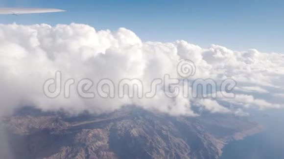 在飞往美国拉斯维加斯的商业航班上在白云上方飞行下面有山脉和湖泊米德视频的预览图