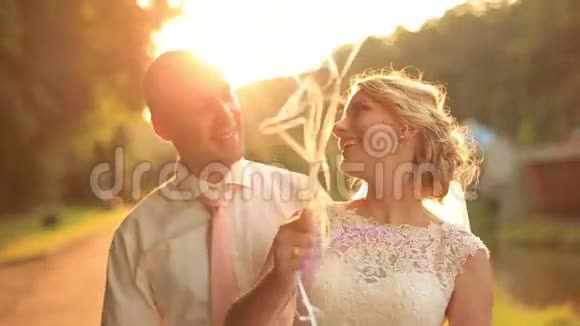 在秋天公园的夕阳背景下带着气球迷人地微笑着的夫妇幸福快乐视频的预览图
