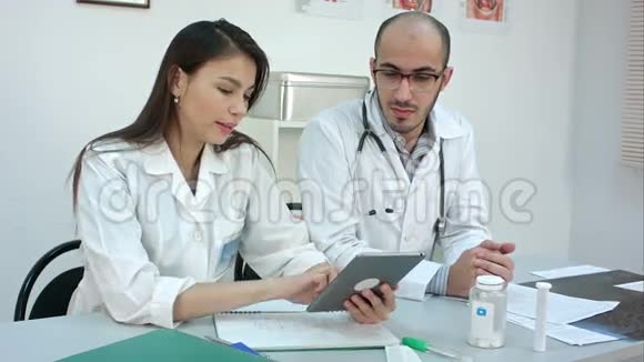 年轻漂亮的护士给她的男同事看药片上的东西视频的预览图