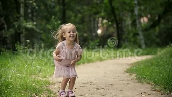 可爱的金发女孩在公园里旋转慢镜头视频的预览图