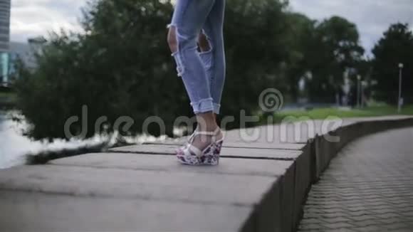 一个穿着楔子的女孩站在河边然后走开了视频的预览图