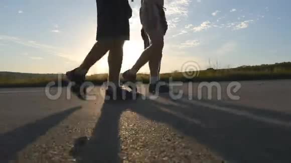 日落时分男性的双脚正走在乡村的道路上靠近三个人正走在一条空荡荡的乡间小路上盖伊过境视频的预览图