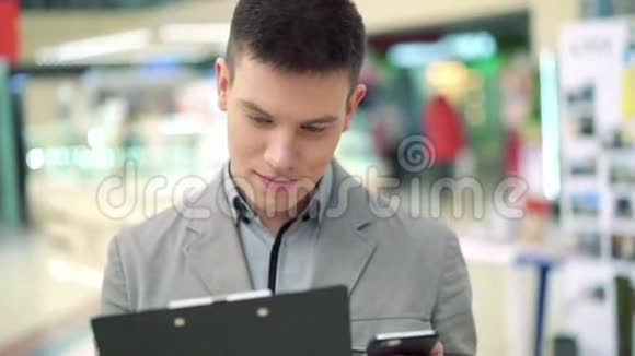 贸易中心的年轻人用电话和笔记本视频的预览图