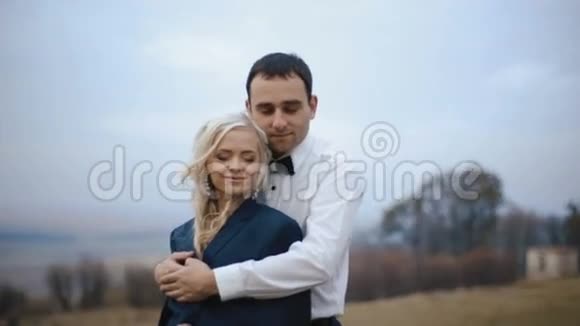 迷人的年轻情侣在寒冷的秋日温柔地拥抱爱情温暖视频的预览图