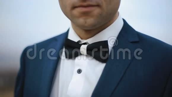 一个穿着燕尾服和领结的优雅男人的户外特写镜头视频的预览图